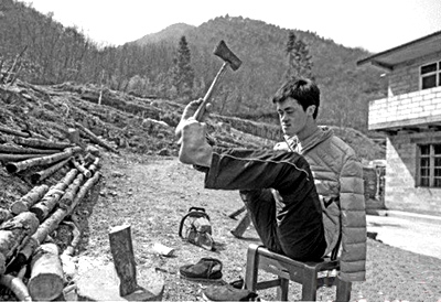 陈兹方在家中劈柴干活