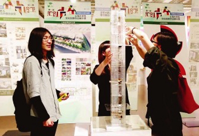 在首届“汇创青春”——上海大学生文化创意作品展示活动中，同济大学研究生梁芊荟(右)在展示她的作品《应对雾霾的核心筒原型——城市空气基础设施设计》。黄艾娇摄