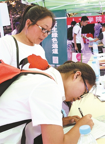 郭慧敏母女来到学校专门为家庭经济困难新生设立的“绿色通道”办理入学手续