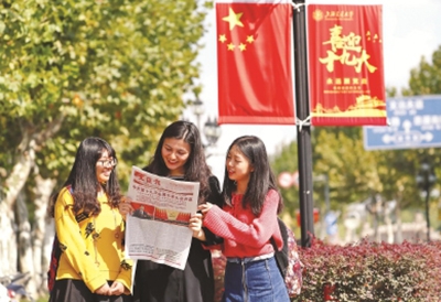 上海交通大学的少数民族学生与汉族学生一起通过阅读报纸等方式学习十九大精神