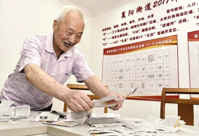 84岁的老党员丁昆源在整理剪报，为宣讲做准备