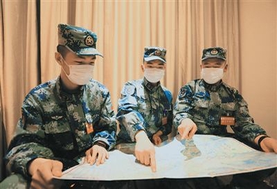 马鑫龙、徐锐、刘文康（从左至右）三人对照地图规划第二天的行车路线.jpg