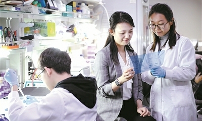 北京大学未来技术学院副院长刘颖（中）在实验室与学生交流.jpg