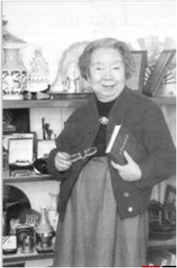 1992年11月6日,谢希德在家中手扶《半导体物理》一书留影。